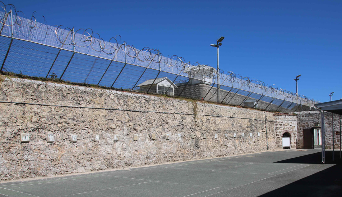 Stone walls, barbed wire and watch towers. Cell with Painting on the Walls, Fremantle Prison,  Fremantle, Western Australia