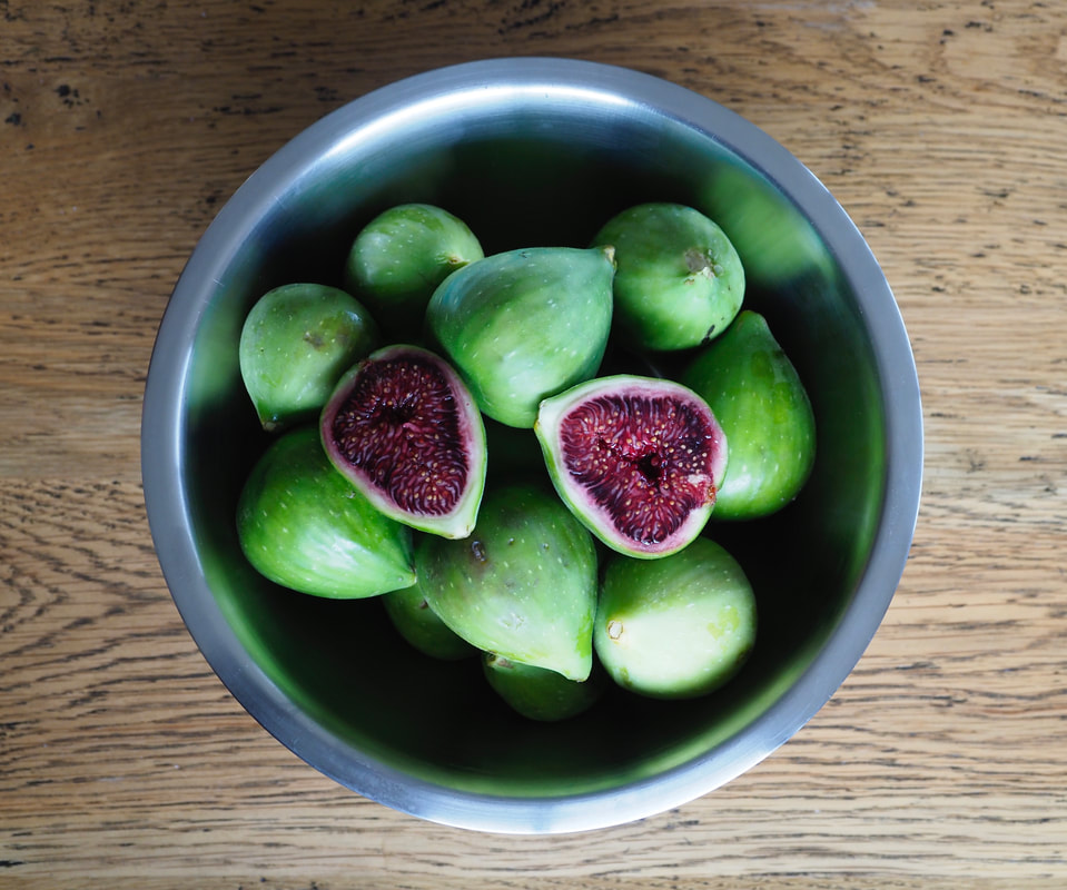 Bowl of figs. Halved fig. Half fig. Ripe fruit.