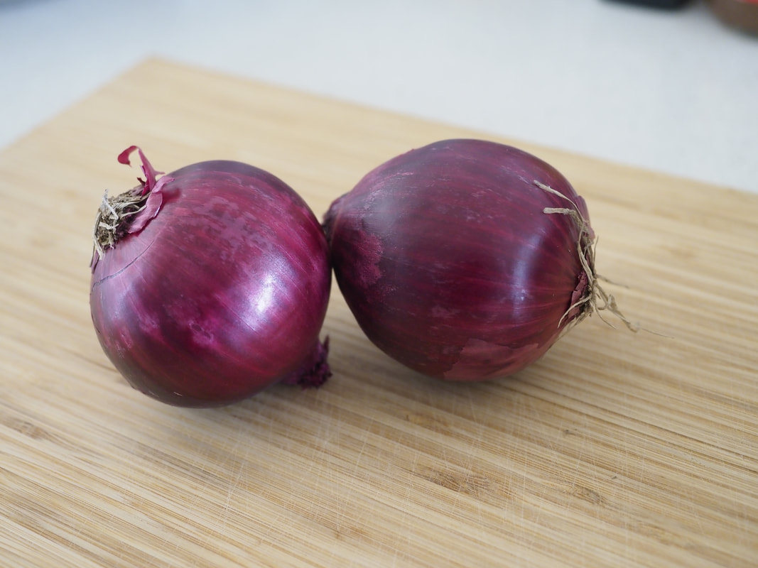 Purple onions on a chopping board.