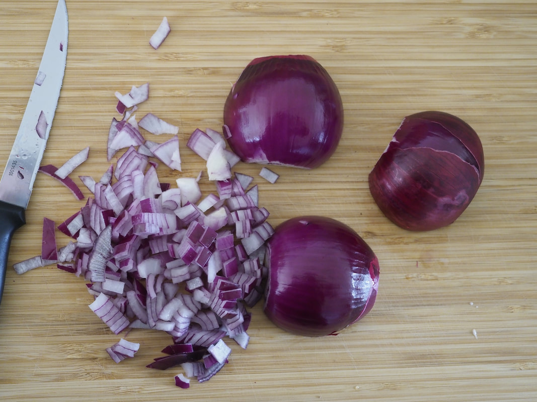 Diced purple onions on a chopping board.