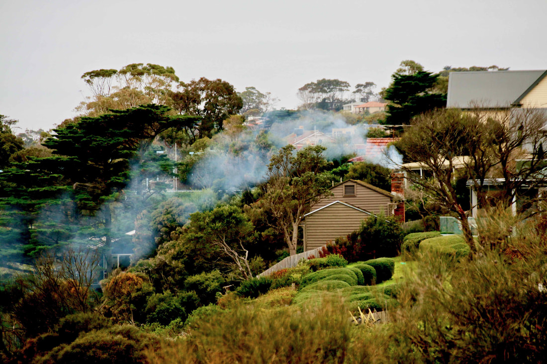 Winter in Mount Eliza, Australia. Smoke from a chimney drifts down towards the ocean. 