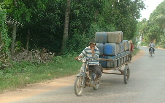 Roads around Siem Reap, Cambodia. Motorcycle with a load.